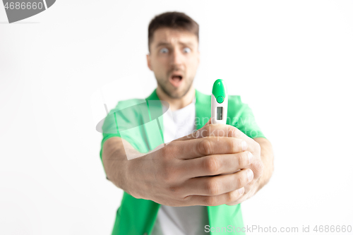 Image of Upset man looking in pregnancy test. Frustrated model