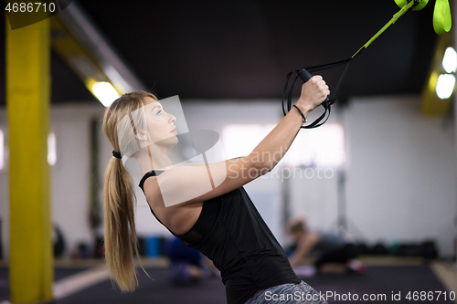 Image of woman working out pull ups with gymnastic rings
