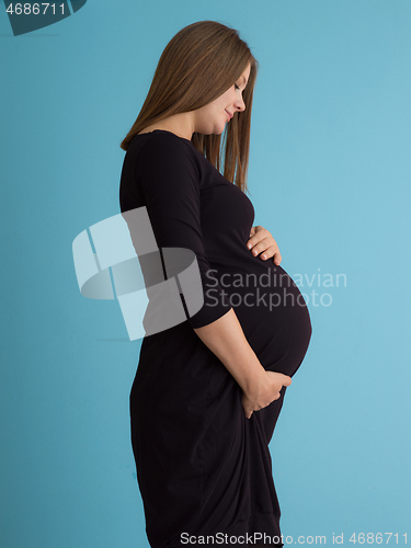 Image of Portrait of pregnant woman over blue background