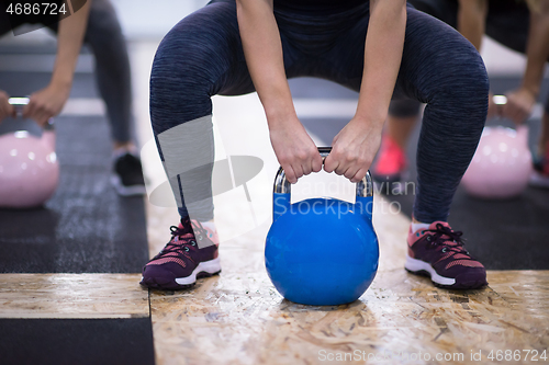 Image of athletes doing exercises with kettlebells