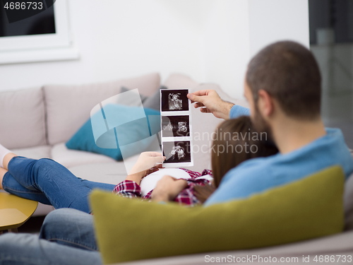 Image of pregnant couple looking baby\'s ultrasound