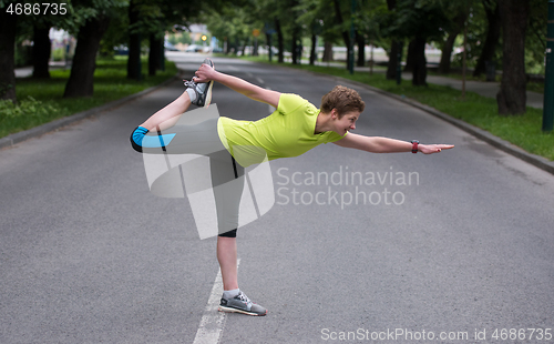 Image of female runner warming up and stretching before morning training