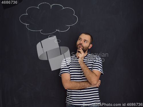 Image of young future father thinking in front of black chalkboard