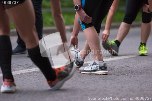 Image of runners team warming up and stretching before morning training