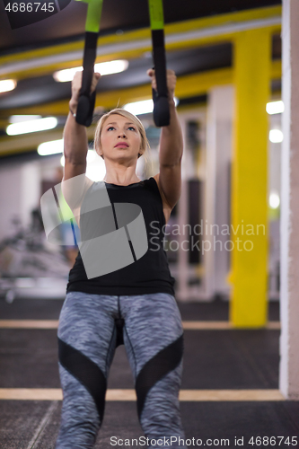 Image of woman working out pull ups with gymnastic rings