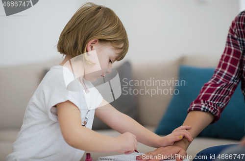 Image of daughter painting nails to her pregnant mom