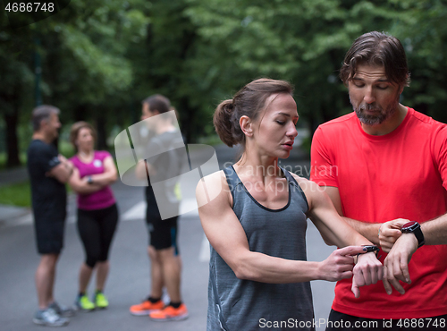 Image of sporty couple using smart watches