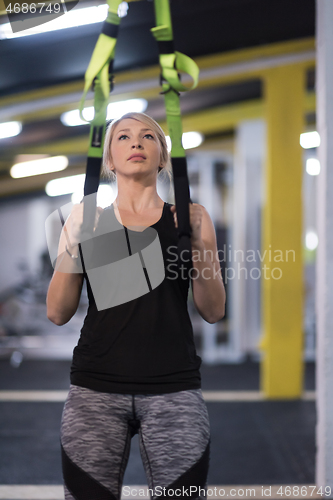 Image of woman working out pull ups with gymnastic rings