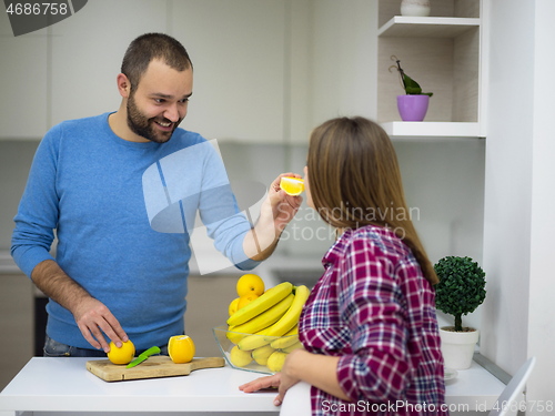 Image of couple cooking food fruit lemon juice at kitchen