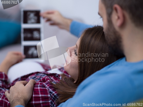 Image of pregnant couple looking baby\'s ultrasound