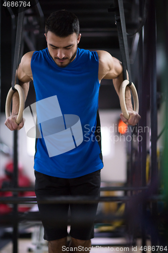 Image of man working out pull ups with gymnastic rings