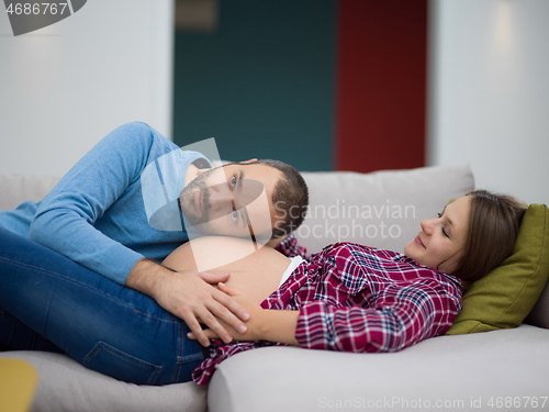 Image of future dad listening the belly of his pregnant wife