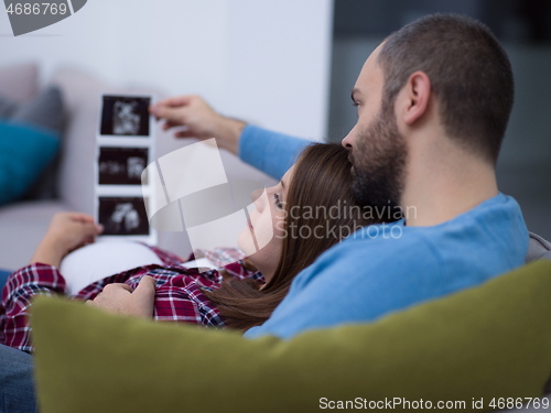 Image of pregnant couple looking baby\'s ultrasound