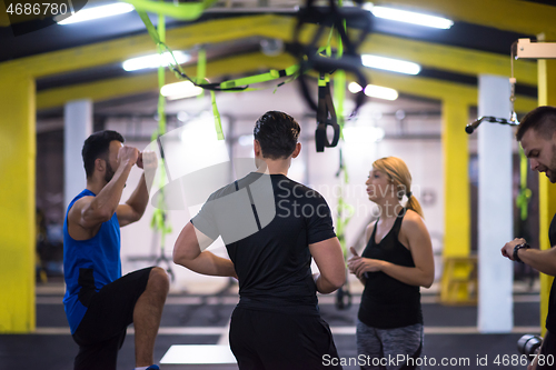 Image of athletes working out  jumping on fit box