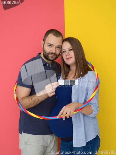 Image of pregnant couple  isolated over colorful background