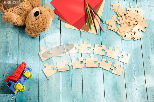 Image of Concept of mock up and pieces of puzzles on the background of wooden table