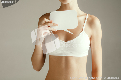 Image of Young adult woman holding empty paper card for sign or symbol.