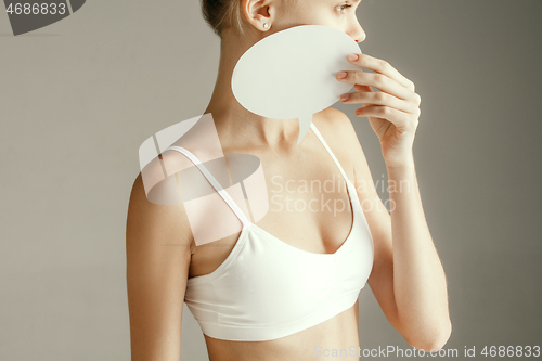 Image of Young adult woman holding empty paper card for sign or symbol.