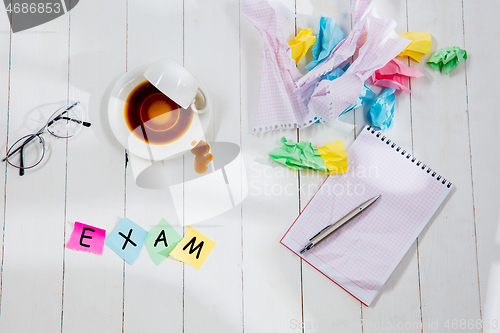 Image of Stationery and word EXAM made of letters on wooden background