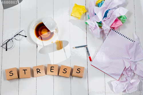 Image of Stationery and word STRESS made of letters on wooden background