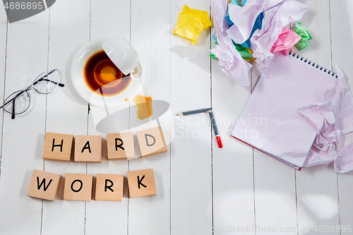 Image of HARD WORK. Message in wooden cubes on a desk background.