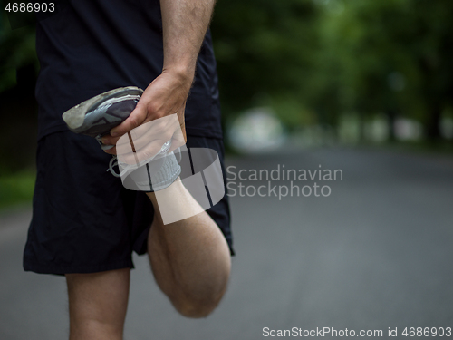 Image of male runner warming up and stretching before morning training
