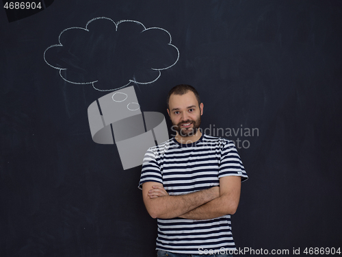 Image of young future father thinking in front of black chalkboard