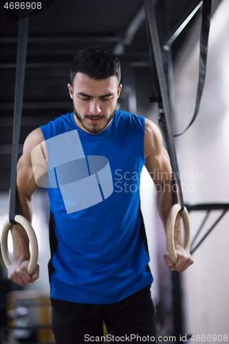 Image of man working out pull ups with gymnastic rings