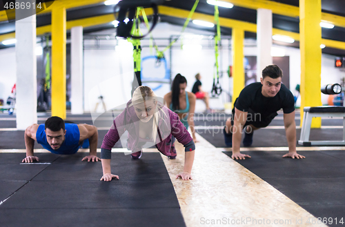 Image of young healthy people doing pushups