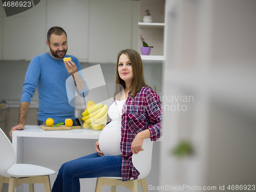 Image of couple cooking food fruit lemon juice at kitchen
