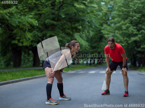 Image of runners team warming up and stretching before morning training