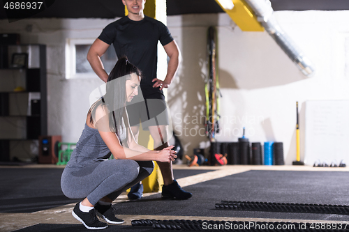 Image of sports couple doing battle ropes cross fitness exercise