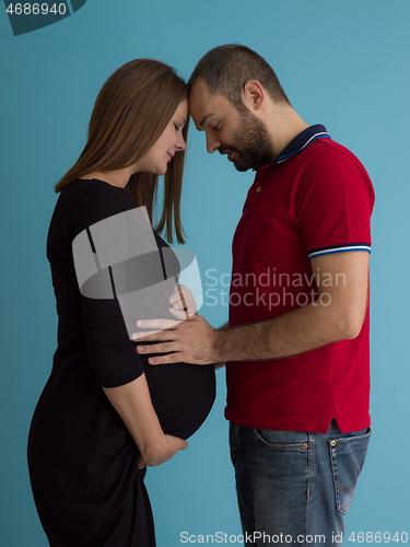 Image of pregnant couple  isolated over blue background