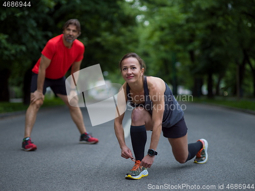 Image of sporty woman tying running shoes laces