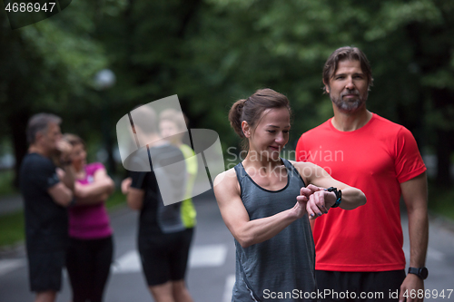 Image of sporty couple using smart watches