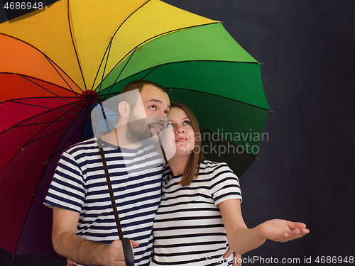 Image of pregnant couple posing with colorful umbrella