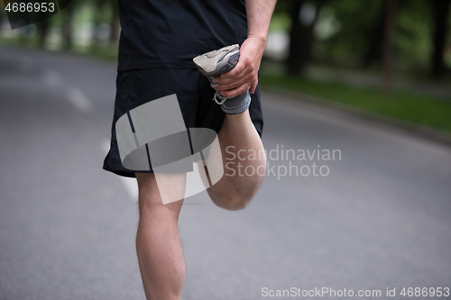 Image of male runner warming up and stretching before morning training