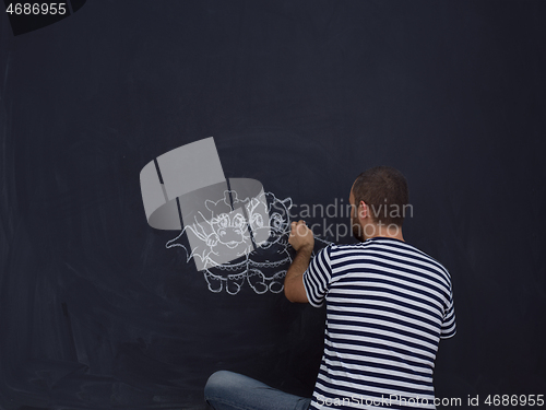 Image of future dad drawing his imaginations on chalk board