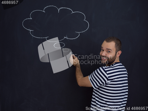 Image of young future father thinking in front of black chalkboard