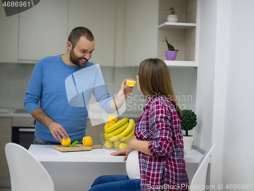 Image of couple cooking food fruit lemon juice at kitchen