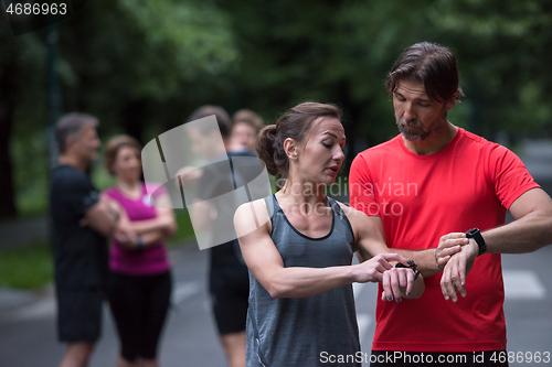 Image of sporty couple using smart watches