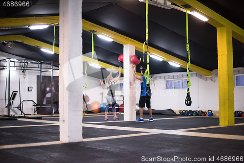 Image of young athletes couple working out with medical ball