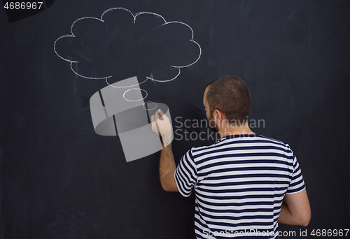 Image of young future father thinking in front of black chalkboard