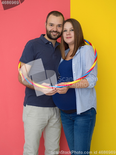 Image of pregnant couple  isolated over colorful background