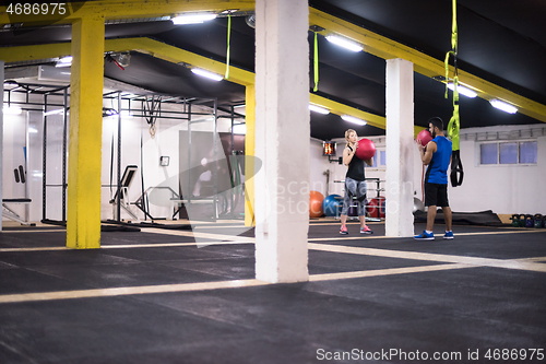 Image of young athletes couple working out with medical ball