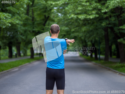 Image of male runner warming up and stretching before morning training