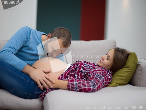 Image of future dad listening the belly of his pregnant wife