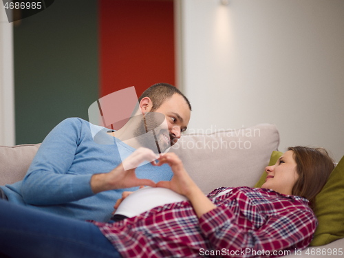 Image of man and pregnant woman showing heart sign