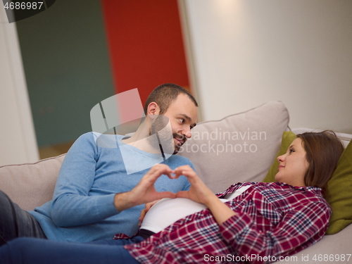 Image of man and pregnant woman showing heart sign