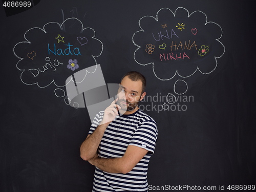 Image of young future father thinking in front of black chalkboard